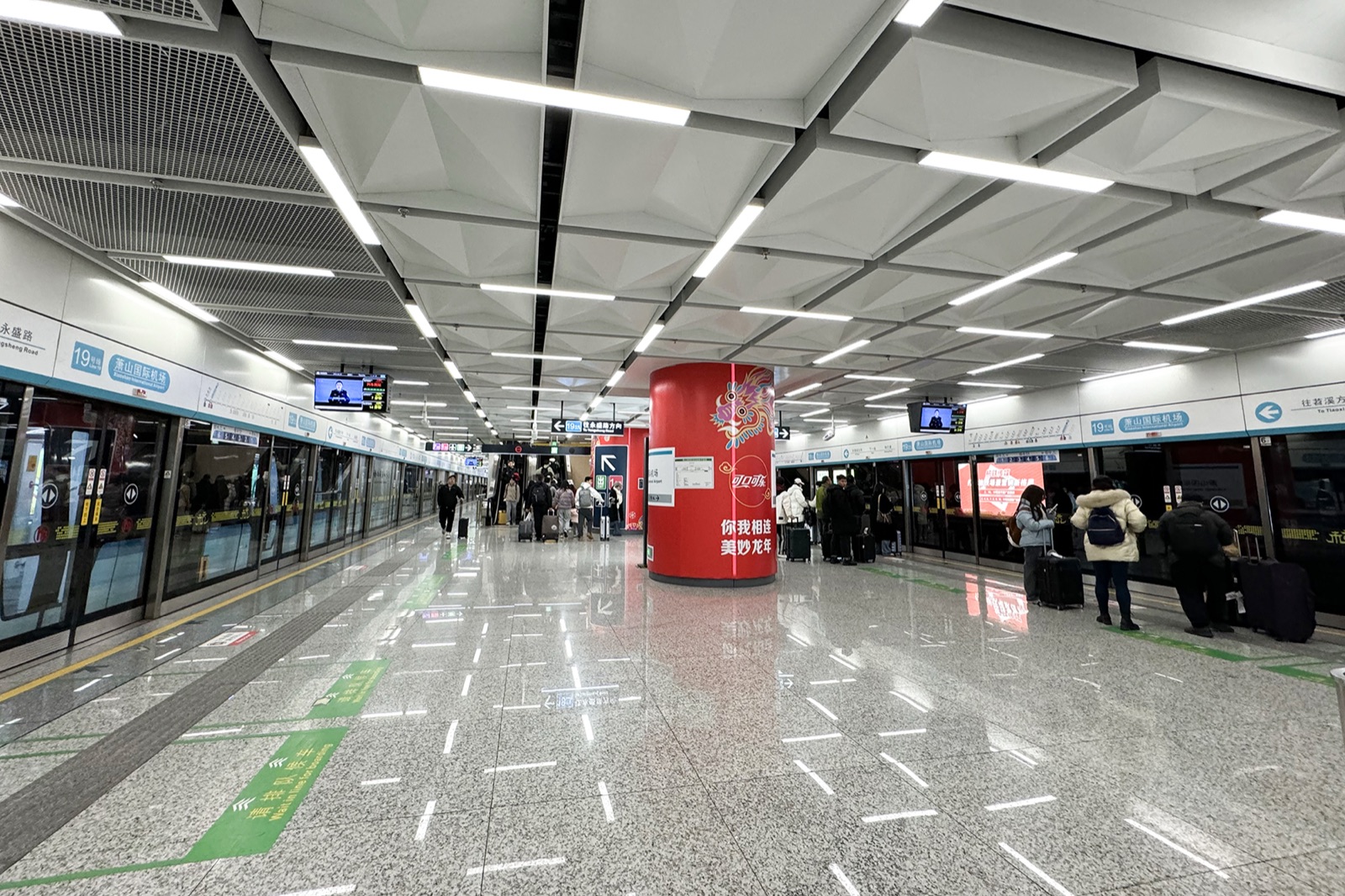 Line 19 Airport Express platform at 萧山机场站 (Xiaoshan Airport Station), travelers boarding toward the city.