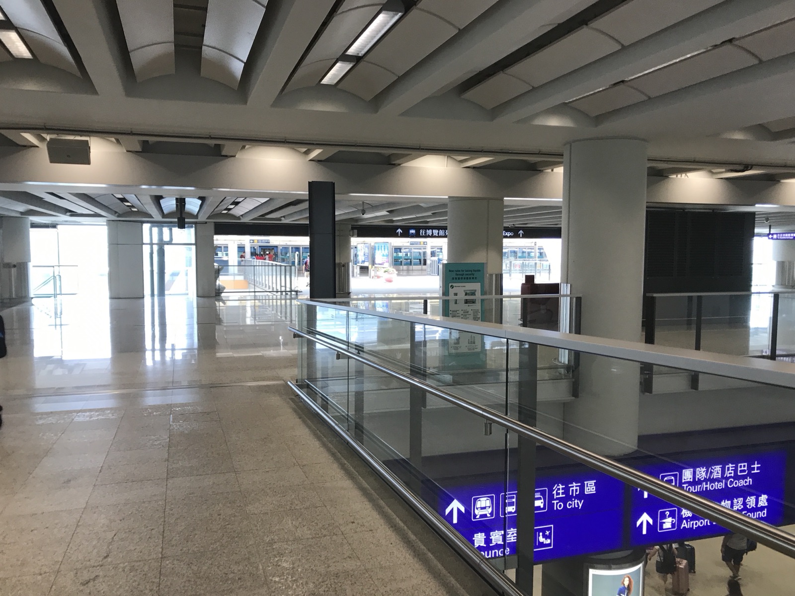 Arrivals signage at Airport Station: 往市區 To City (Airport Express) and hotel/tour coaches.