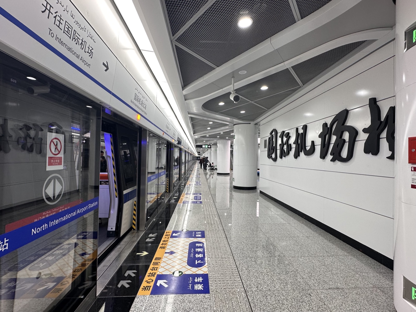 Metro Line 1 platform at the airport, trains toward the city.